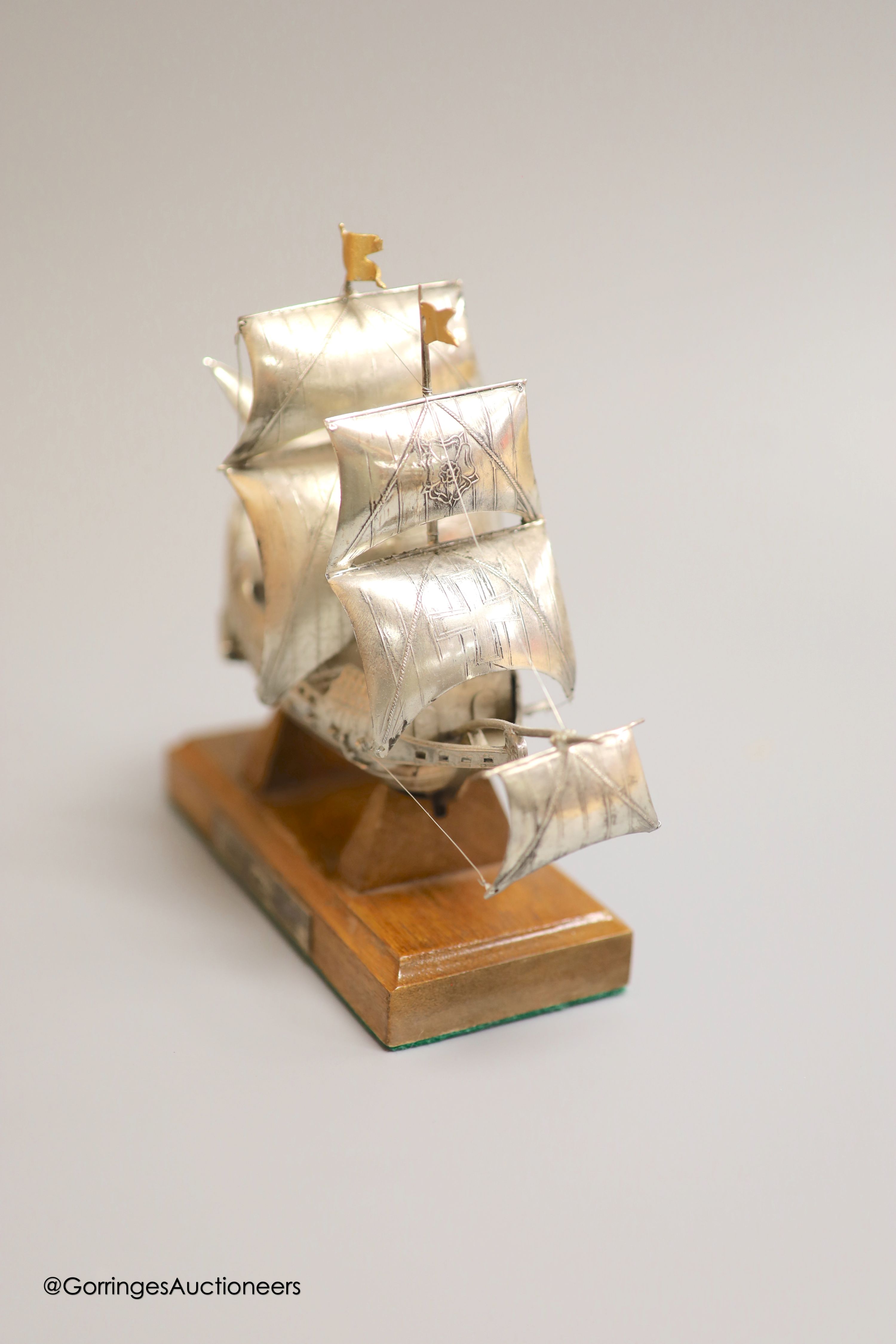 A modern Italian white metal (stamped 925) miniature model of the ship, 'The Golden Hind', (repairs), post 1968 mark, length 16cm, on a wooden stand